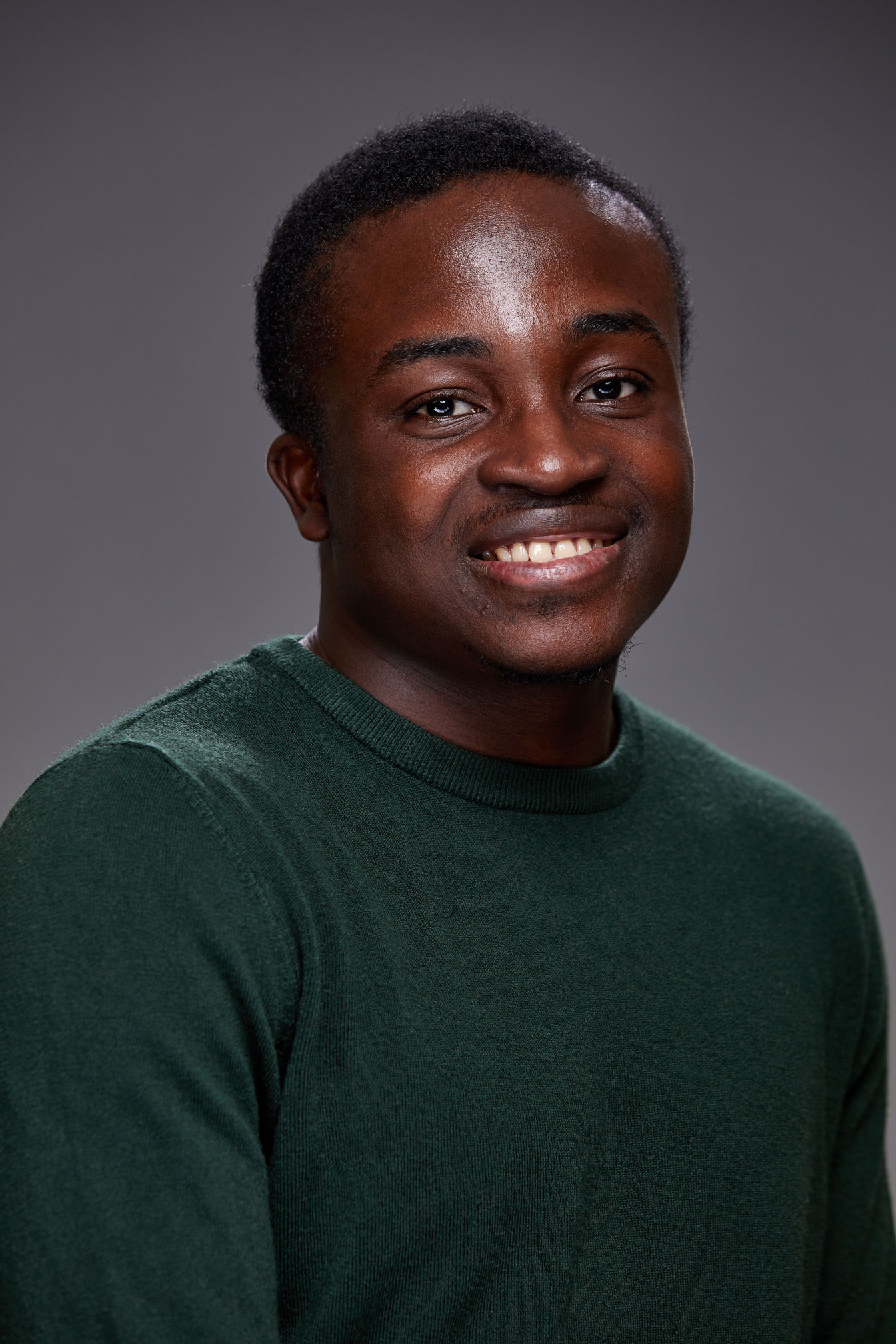 Daniel smiling, wearing a green sweater